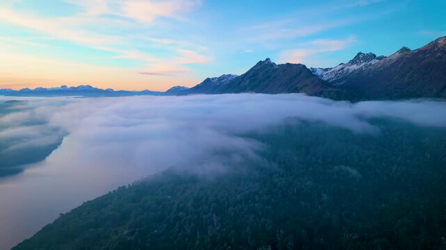 Stunning aerial view of Lake Nahuel Huapi surrounded by morning mist and mountain peaks in Villa La Angostura, Patagonia, Argentina. The scene includes iconic landmarks 