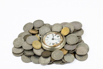 Old pocket watch with rusty dial surrounded by vintage Spanish coins Franco era.