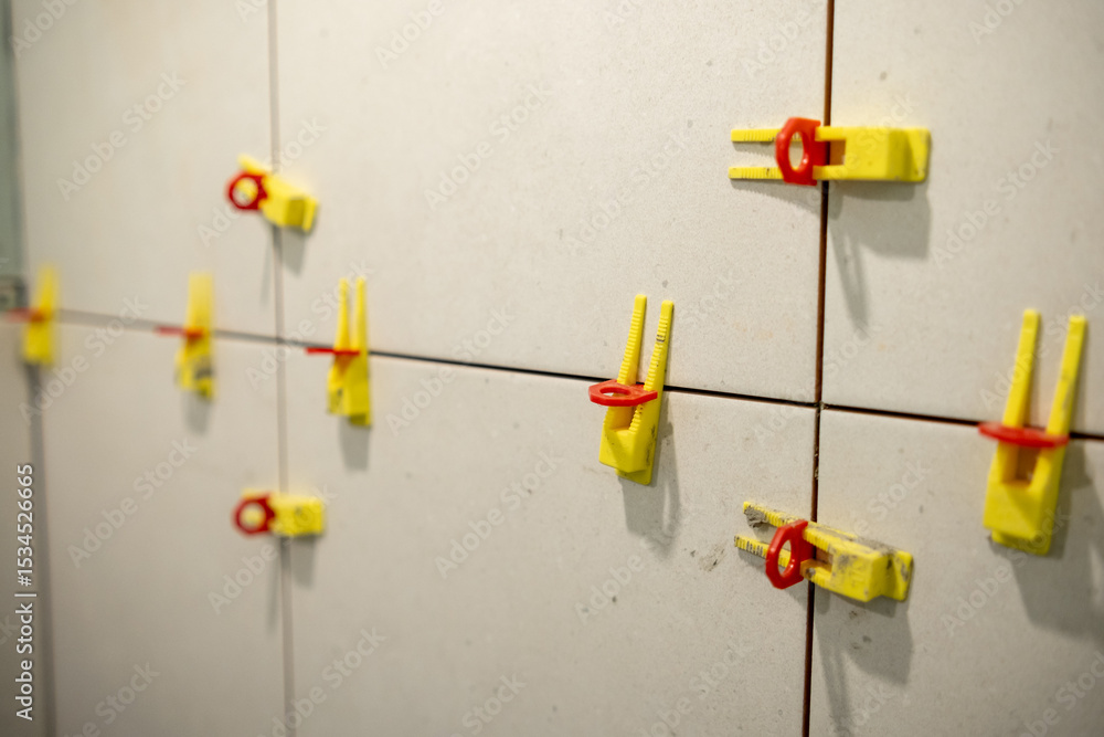 Poster Tools and Materials Used for Tile Installation Displayed on a Wall in a Construction Site During the Day