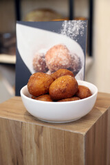 buñuelos dulces recién horneados en un cuenco sobre la tabla de madera rustica