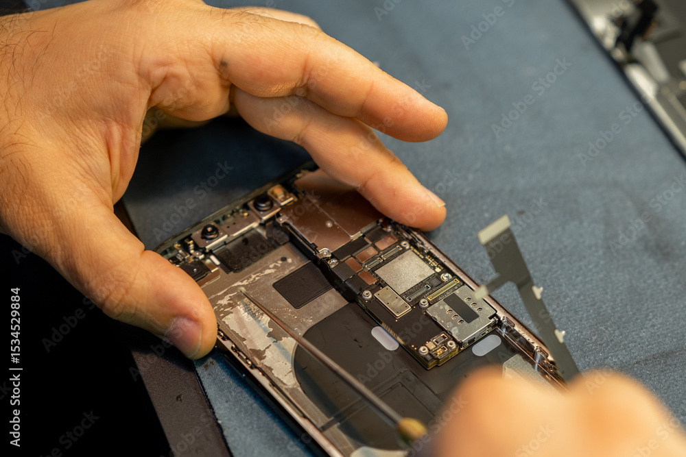 Poster expert phone repair in progress with detailed attention to internal components at a workshop