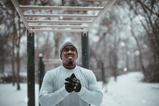 Man preparing for outdoor winter workout under snowy monkey bars in cold weather gear