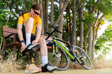 Naklejka premium Professional cyclist putting on cycling shoes before training ride