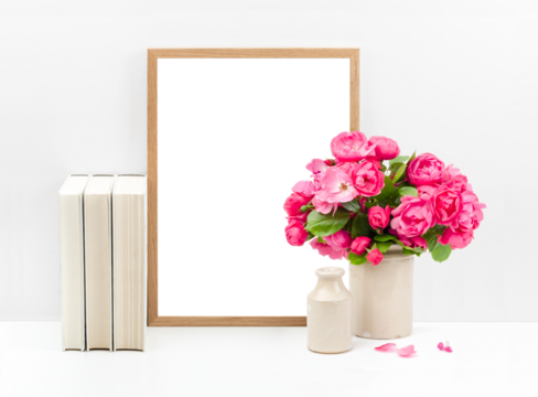 feminine mockup with wooden picture / photo frame, cream colored books and a bunch of roses in a vase on a white shelf or desk against a bright wall, just insert your artwork, poster or photo, PNG 