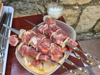 Outdoor summer barbecue with skewered meat and onions for grilling party