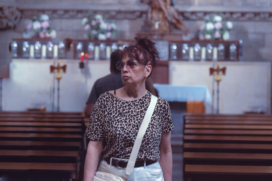 Senior woman standing in a church during a moment of recollection