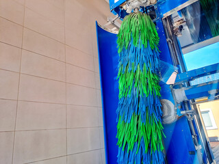 automatic car wash brush in action. A car goes through an automated car wash.