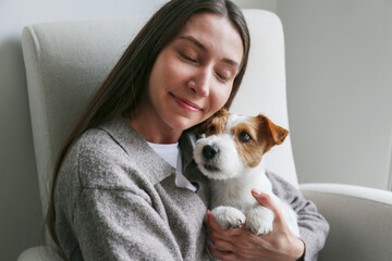 Young woman hugging her dog. Copy space, background.