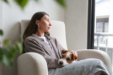 Young woman relaxing at home with her dog. Copy space, background.