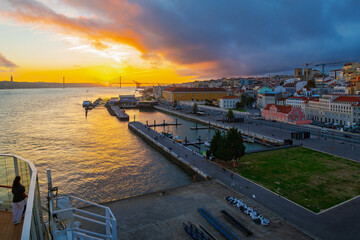 Sunset view from the upper deck of a cruise ship at port of the city of Lisbon Portugal, Tagus River and the Ponte 25 de Abril bridge.