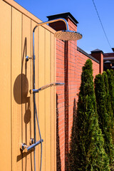 Summer shower against the wall outside. Shower near the pool. Vacation outside the city