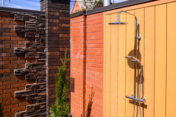 Summer shower against the wall outside. Shower near the pool. Vacation outside the city