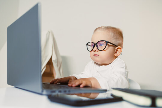 Stylish 2 year old boy child in office. Serious little children business man. Young toddler businessman. Little boss in office. Young businessman using laptop.