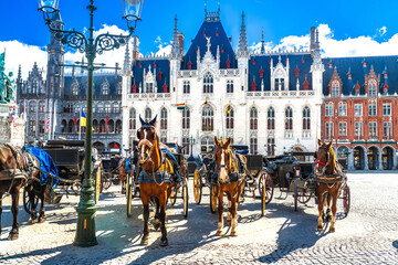 Bruges, Belgium.  Horse carriages on Market square in Brugge old town, Bruges city historical centre