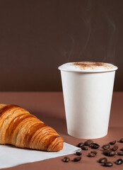 Pan croissant con café caliente y granos de café