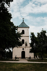 A historic Orthodox church of Saints Peter and Paul near Zlatibor, Serbia. Surrounded by trees and gravestones, this peaceful church features a bell tower with a cross and religious painting