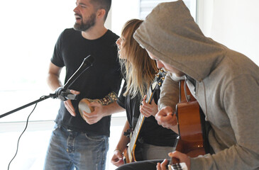 a group of young people play music on musical instruments. a young musical group plays the guitar...