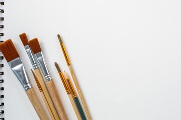 Clean white background of drawing paper with paint brushes