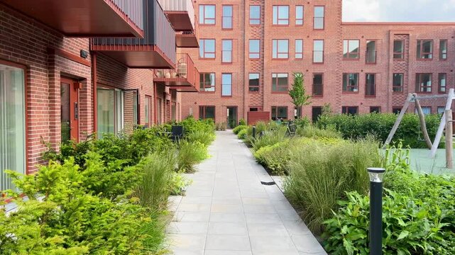 Herning, Denmark - June 12, 2025: Modern architecture apartments in Denmark summer days. Modern block of flats. A large building with a courtyard in the middle. Danish architecture design. Houses 