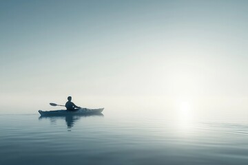 Obraz premium Silhouette of a kayaker paddles across calm waters towards the horizon during a foggy sunrise, solitude, adventure, and serenity.