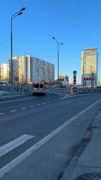 Urban traffic scene featuring vehicles navigating a roundabout, surrounded by modern buildings and clear blue sky, showcasing the dynamics of city life and transportation infrastructure
