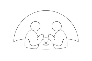 Two people sitting together under an umbrella enjoying a drink