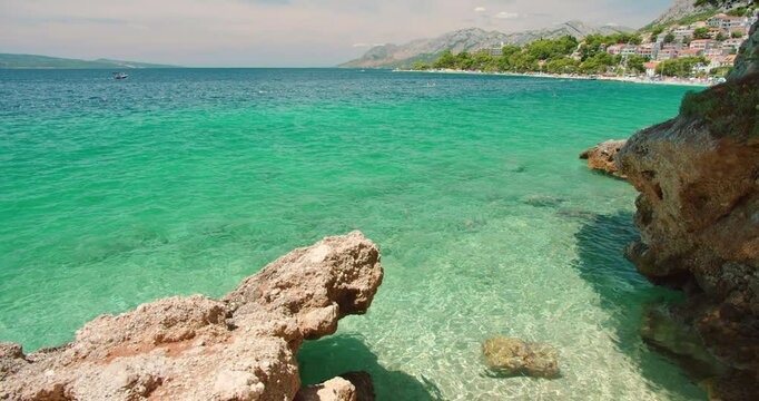 Rocky coast and green blue water near a seaside town in summer Croatia