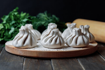 Khinkali with meat on wooden board, georgian cuisine. Side view.