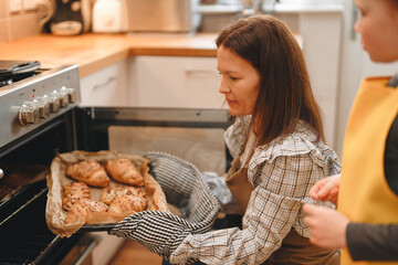 Baking fresh pastries in a cozy kitchen with a mother and child on a sunny afternoon preparing delicious treats together