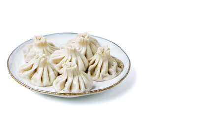 Plate with traditional georgian khinkali (dumplings) isolated on white background. Side view, copy space.
