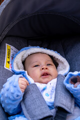 Baby in cozy blue outfit enjoying a stroll on a sunny day