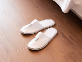 Disposable slippers at the end of the bed