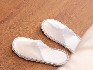 Disposable slippers at the end of the bed