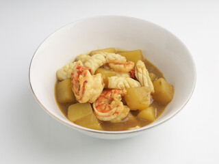 Shrimp and squid curry in white bowl