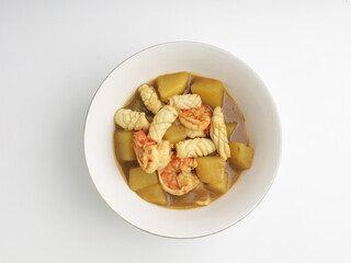 Shrimp and squid curry in white bowl