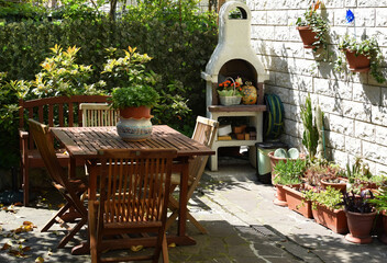 A relaxing outdoor living space with wooden garden furniture and built in stone barbecue area