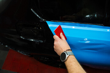 Vehicle wrap detailing involves squeegee strokes for seamless, wrinkle-free adhesion. Detailing...