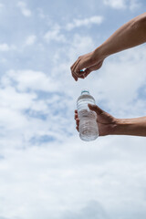 水のペットボトルを開ける人
