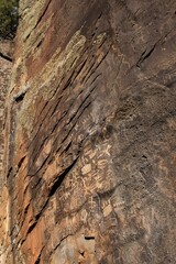 Looking up at petroglyphs on a rock wall at Keyhole Sink, Parks, Arizona.