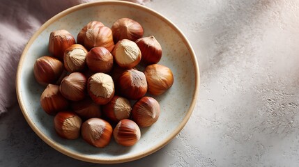 Obraz premium A bowl of hazelnuts on a light-colored surface