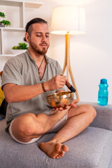 Young man playing tibetan singing bowl at home for meditation and relaxation