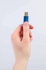 Man with modern flash drive on light grey background, closeup