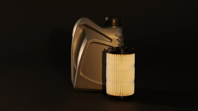 Motor oil in plastic canister and filter on black background, changing direction of light