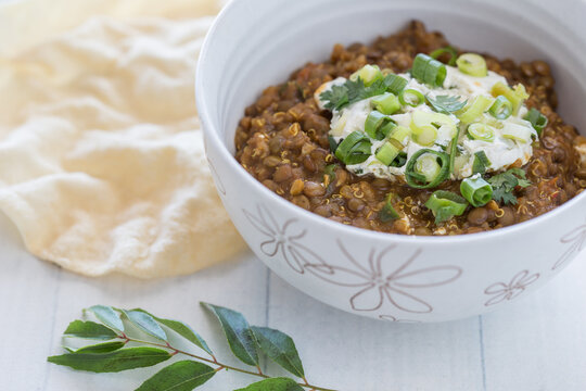 Organic Bowl of vegetarian Lentil Dahl with a papa-dum and lime leaves