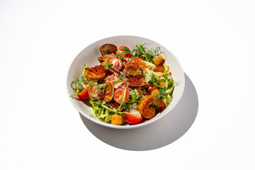 A colorful seafood salad featuring shrimp, clams, crispy croutons, fresh greens, and ripe tomatoes beautifully arranged in a white bowl against a bright backdrop