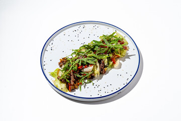 A colorful taco filled with seasoned meat, fresh vegetables, and herbs is presented on a white plate. The dish highlights culinary skill during a lively event, perfect for food lovers