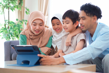 Happy Asian muslim family's portrait in living room.