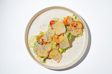 A vibrant salad featuring tender shrimp atop a bed of crisp lettuce, complemented by crunchy toasted bread pieces. The dish is artfully arranged, offering a fresh and healthy meal