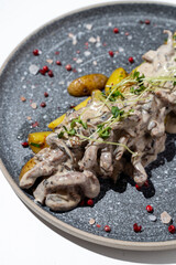 A gourmet dish presents creamy, sautéed mushrooms generously drizzled with a rich sauce, accompanied by tender yellow potatoes and garnished with vibrant herbs for a luxurious dining experience