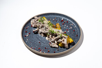 A beautifully plated dish showcases succulent meat draped in a rich, creamy sauce, accompanied by vibrant vegetables and garnished with herbs. Perfect for gourmet dining moments